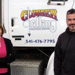 Kevin and Helen Gill own Clouser Drilling and pose in front of one of their drilling rigs