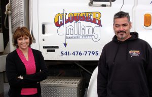 Kevin and Helen Gill own Clouser Drilling and pose in front of one of their drilling rigs