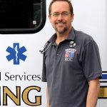 Gary Heigel EMS instructor at RCC posing in front of a training ambulance