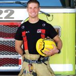 patrick bailey, and EMS RCC success story poses in front of a fire truck