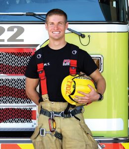 patrick bailey, and EMS RCC success story poses in front of a fire truck