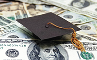 stack of money with a graduation cap on top