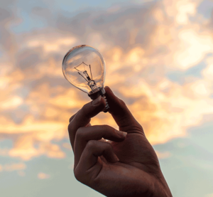 holding a lightbulb to the sky as a visual representation of innovation