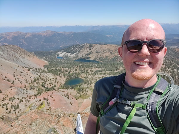 Picture of Nathan Breeden with mountains and lakes in the background.